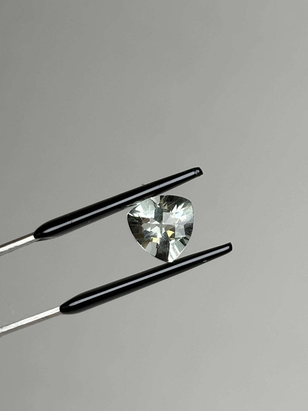 Front of trillion cut (triangular) light green stone 8 mm in size