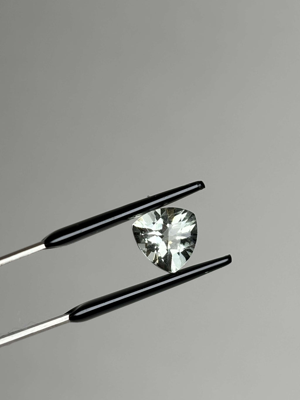 Front of trillion cut (triangular) light green stone 8 mm in size