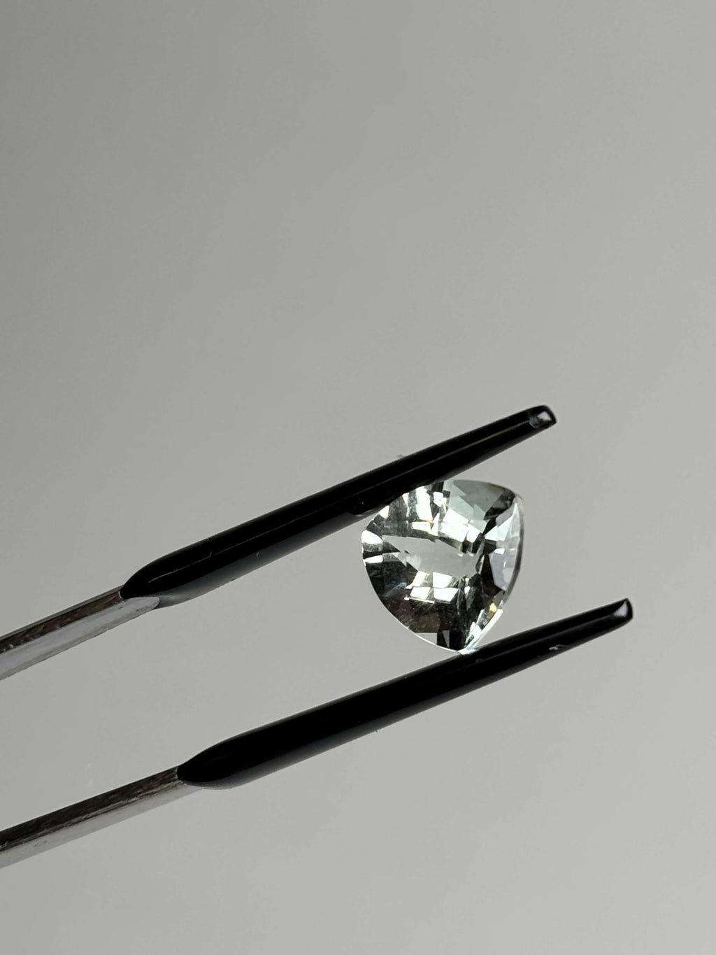 Front of trillion cut (triangular) light green stone 8 mm in size