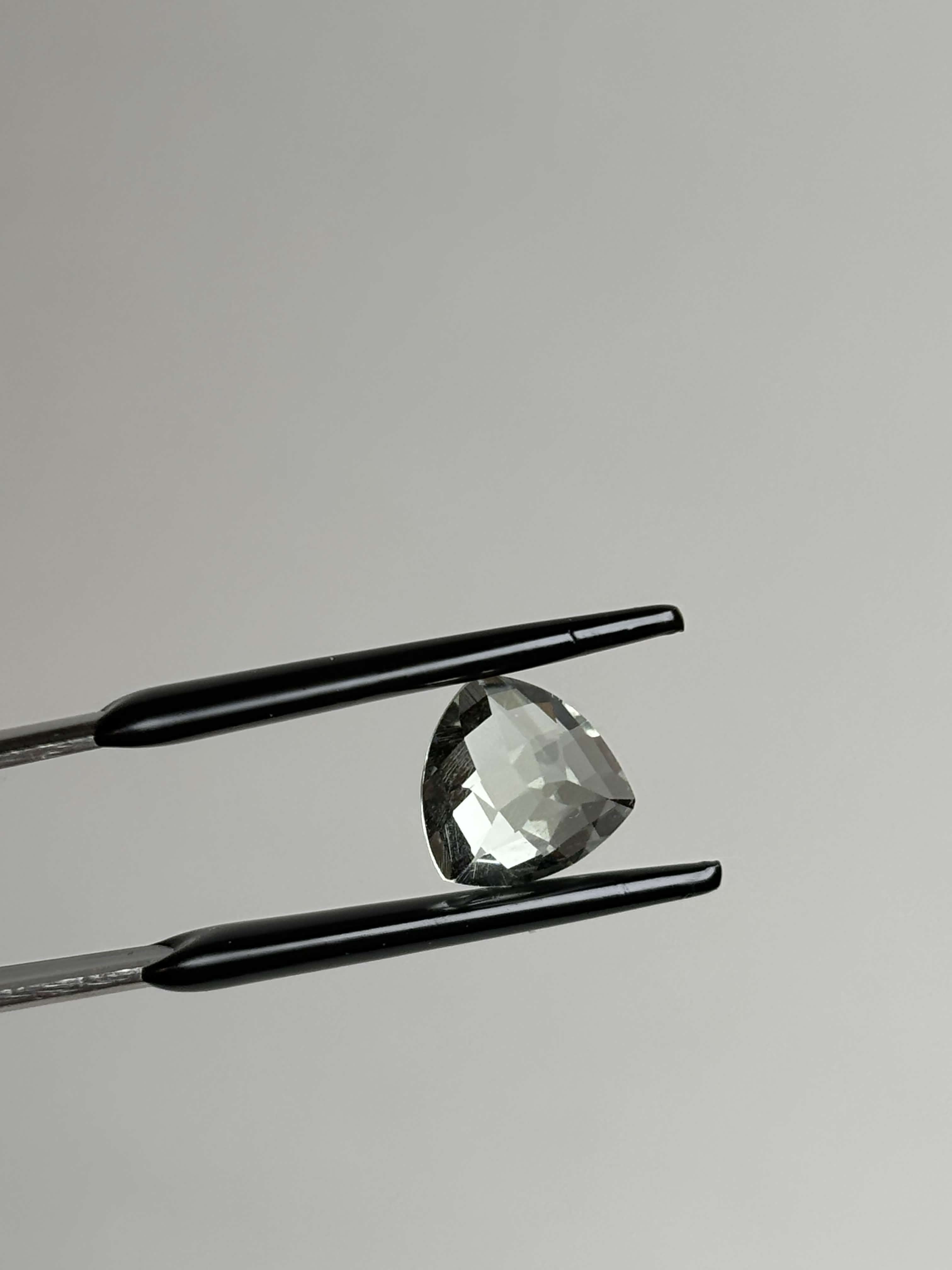 Back of trillion cut (triangular) light green stone 8 mm in size