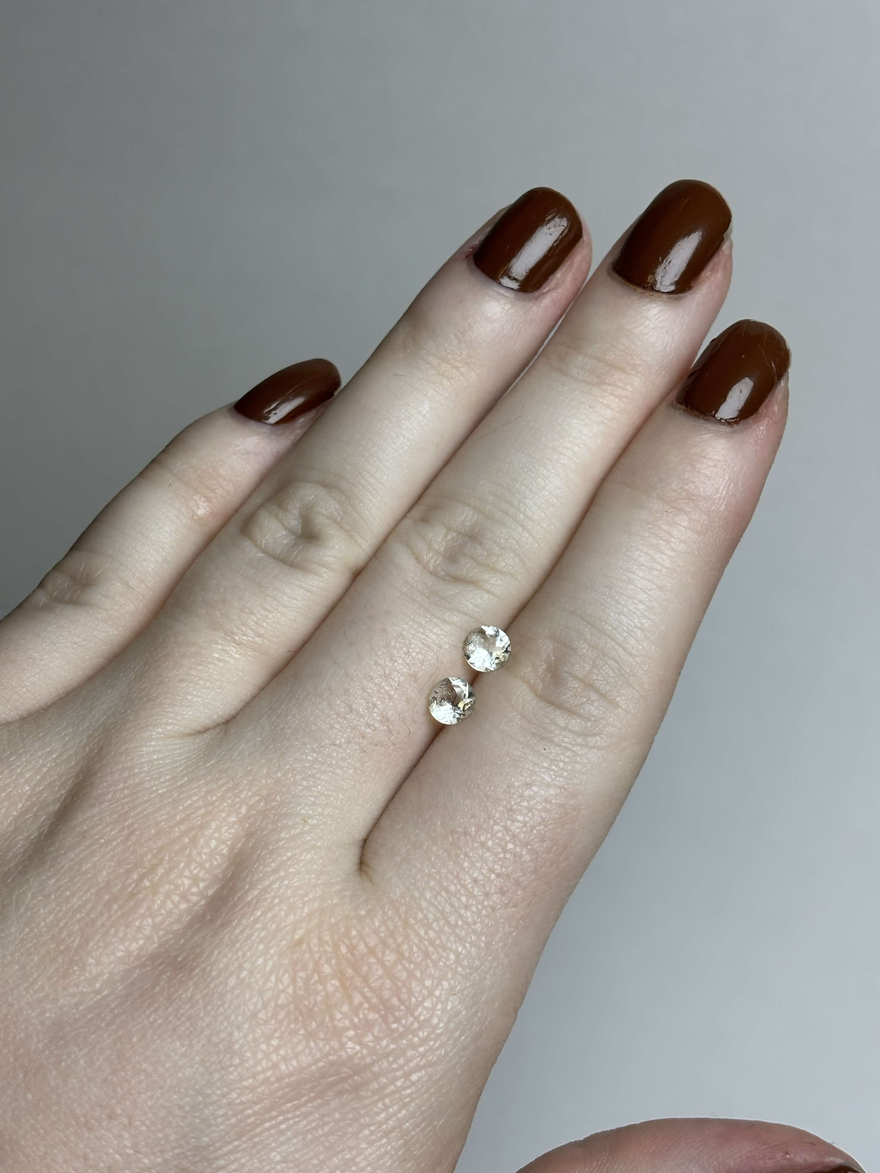 Two round pale green stones on a hand