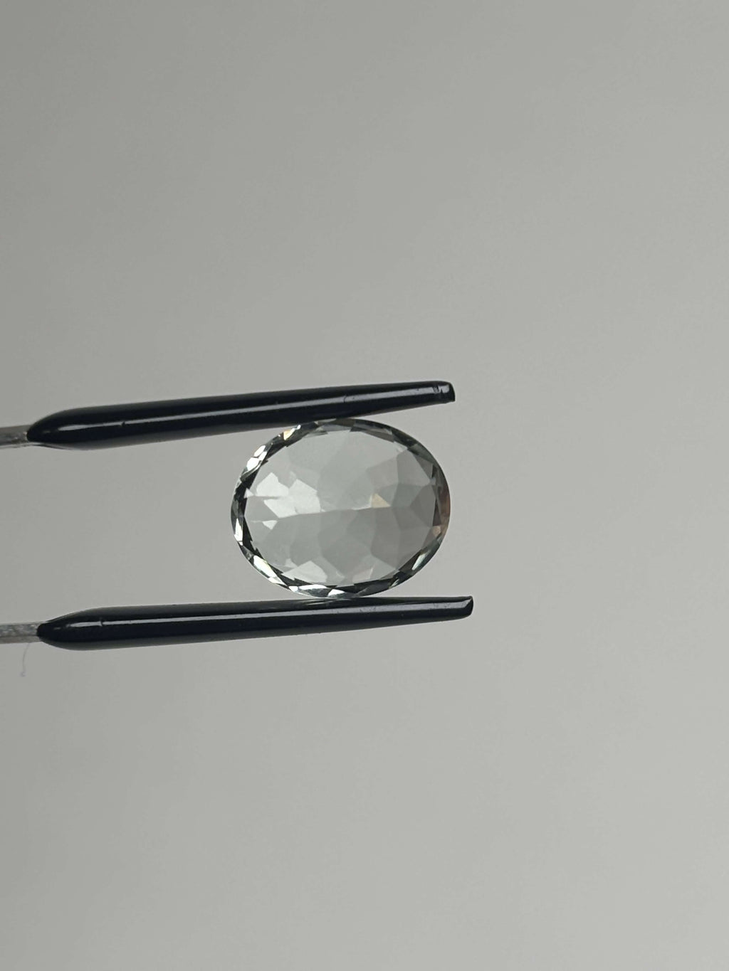 Back of pale green faceted stone