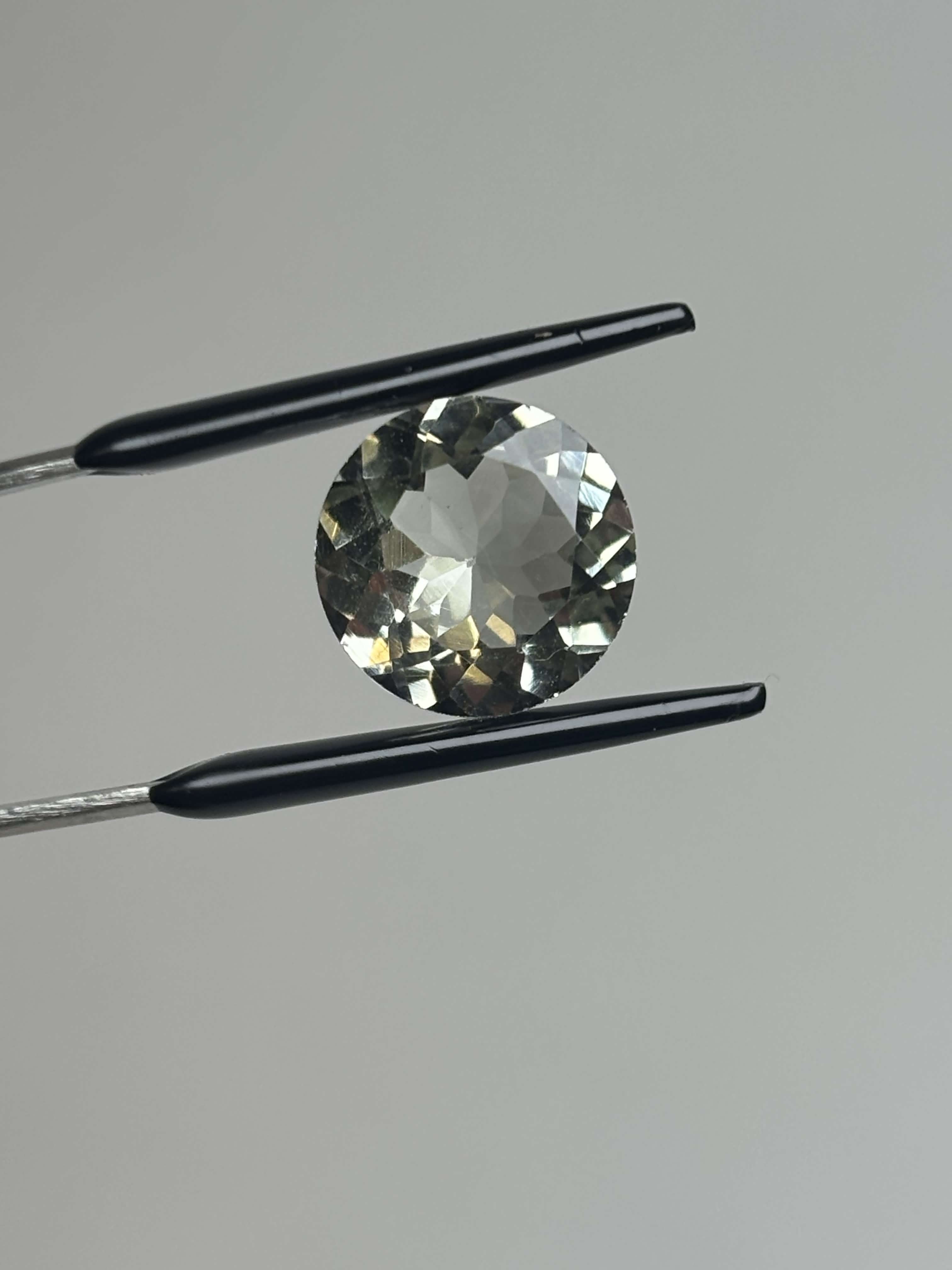 Front of pale green faceted round stone