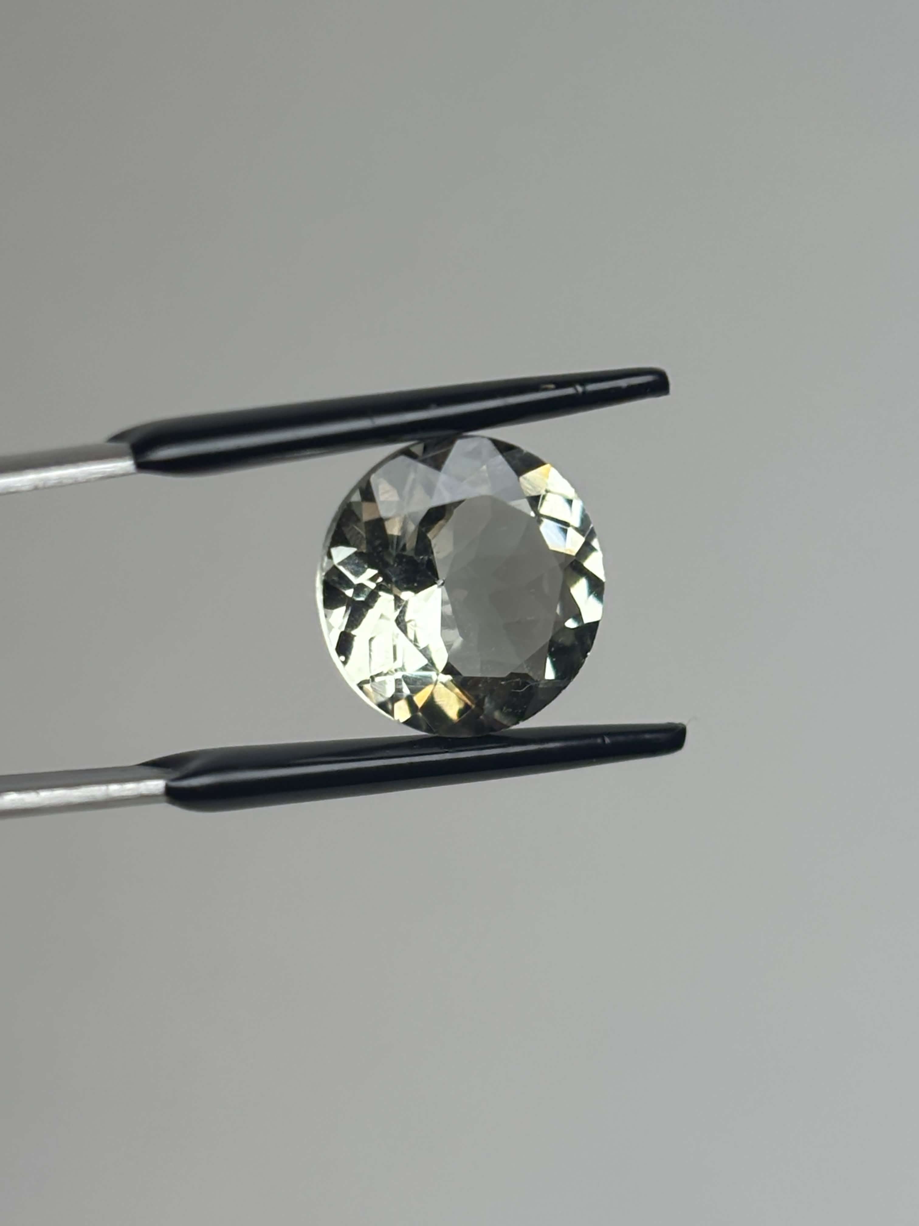 Front of pale green faceted round stone