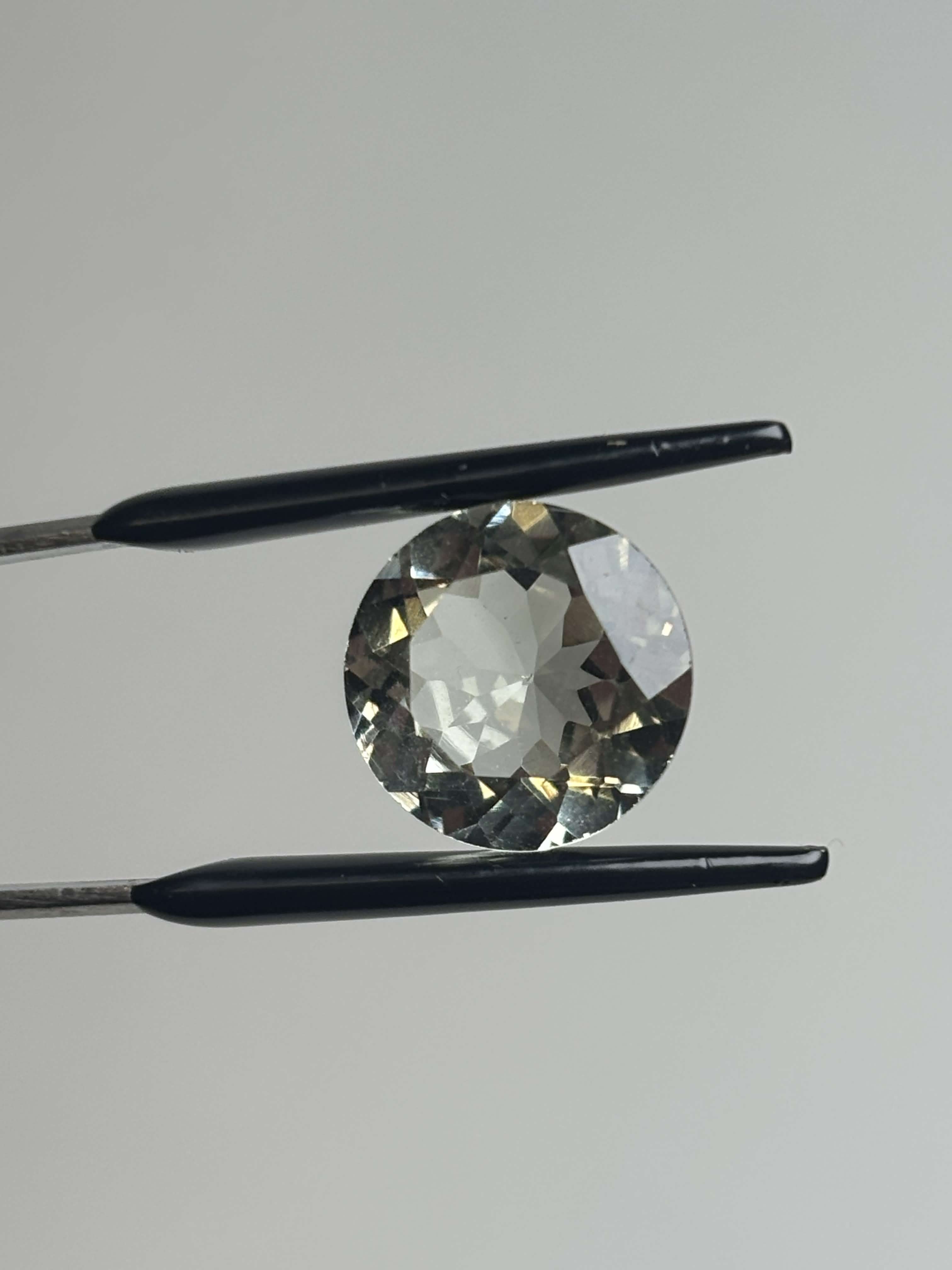 Front of pale green faceted round stone