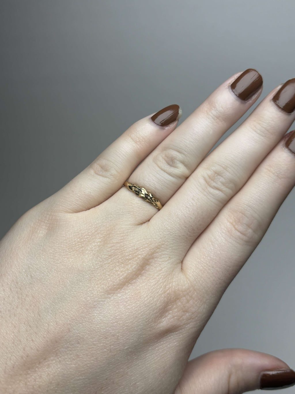 Yellow gold etched chevron band ring on hand